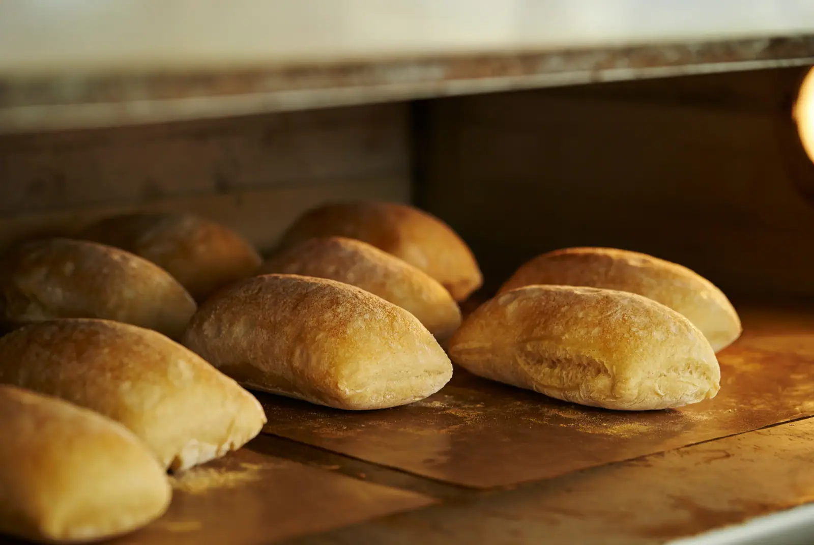Frisch gebackene, goldbraune Brötchen liegen in einem professionellen Ofen