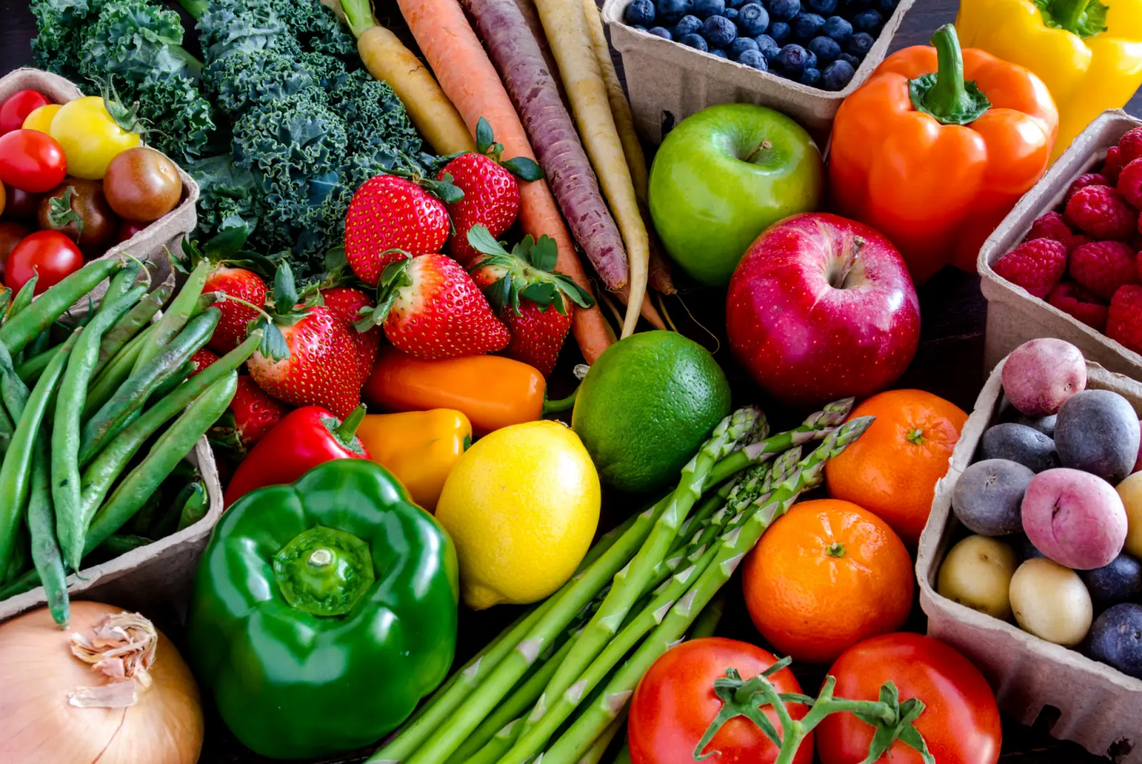 Bunte Vielfalt an frischem Obst und Gemüse wie Paprika, Karotten, Beeren und Äpfeln dekorativ angerichtet