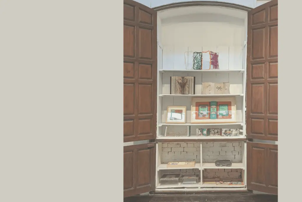 Ein offener Holzschrank mit weißen Regalböden, auf denen dekorative Kunstwerke und Bücher ausgestellt sind