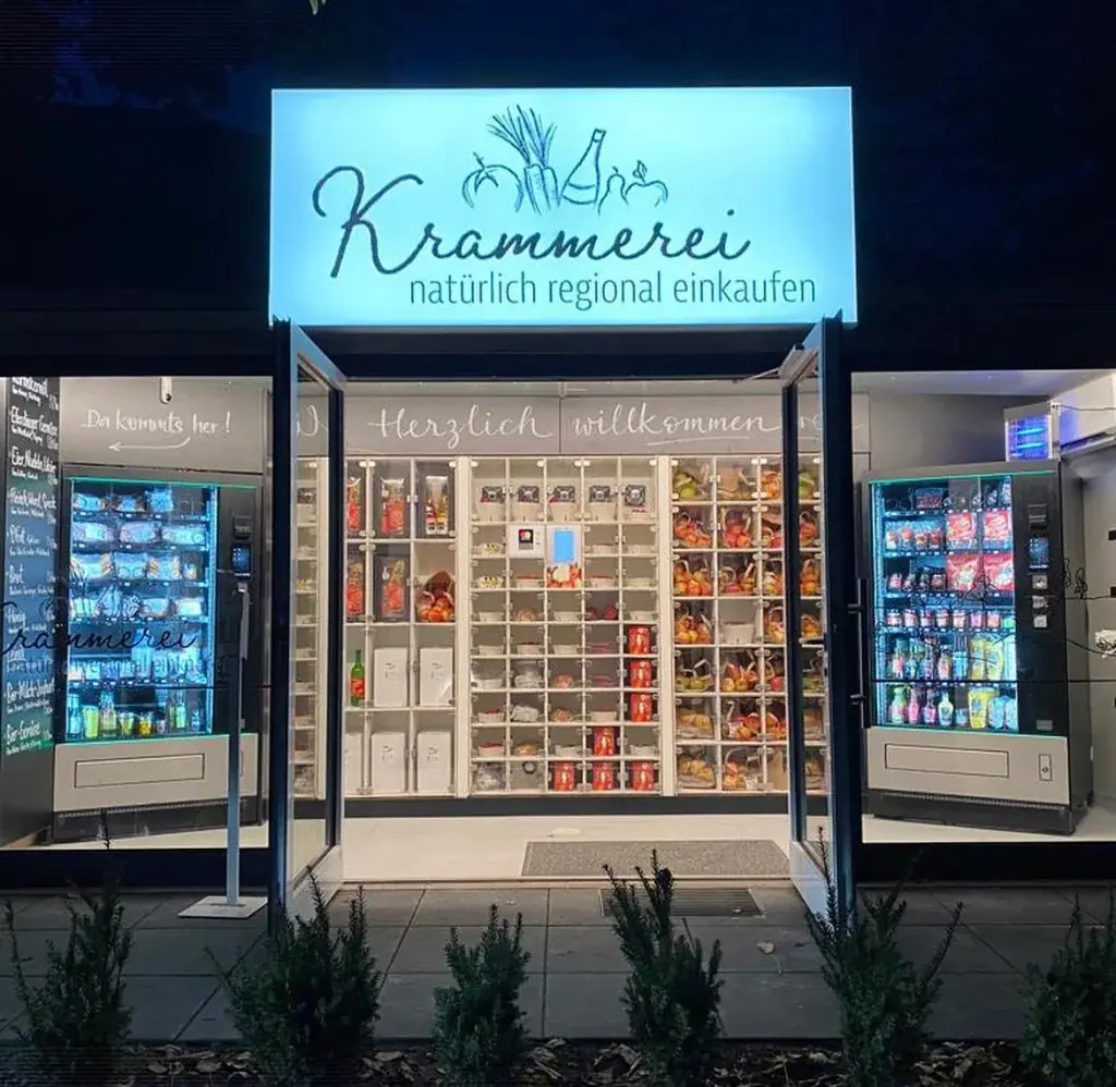 Beleuchteter Automaten-Kiosk Krammerei mit regionalen Produkten in verschiedenen modernen Verkaufsautomaten